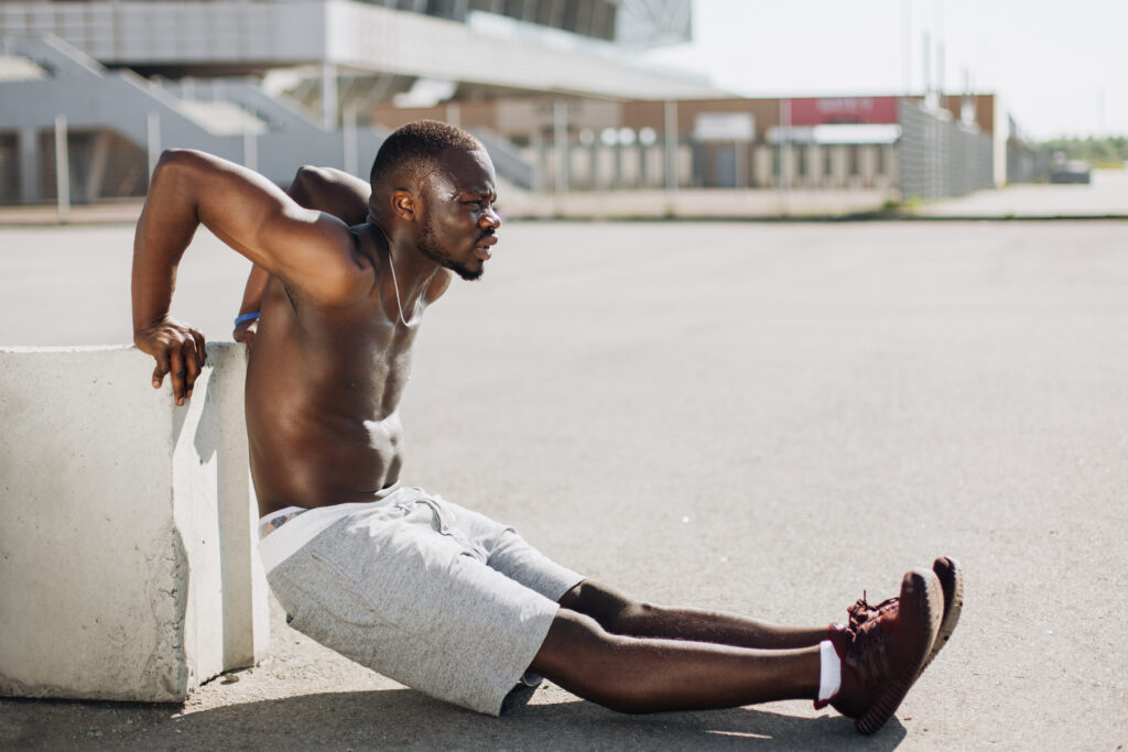 African American man does dips outdoors on his exercise routine